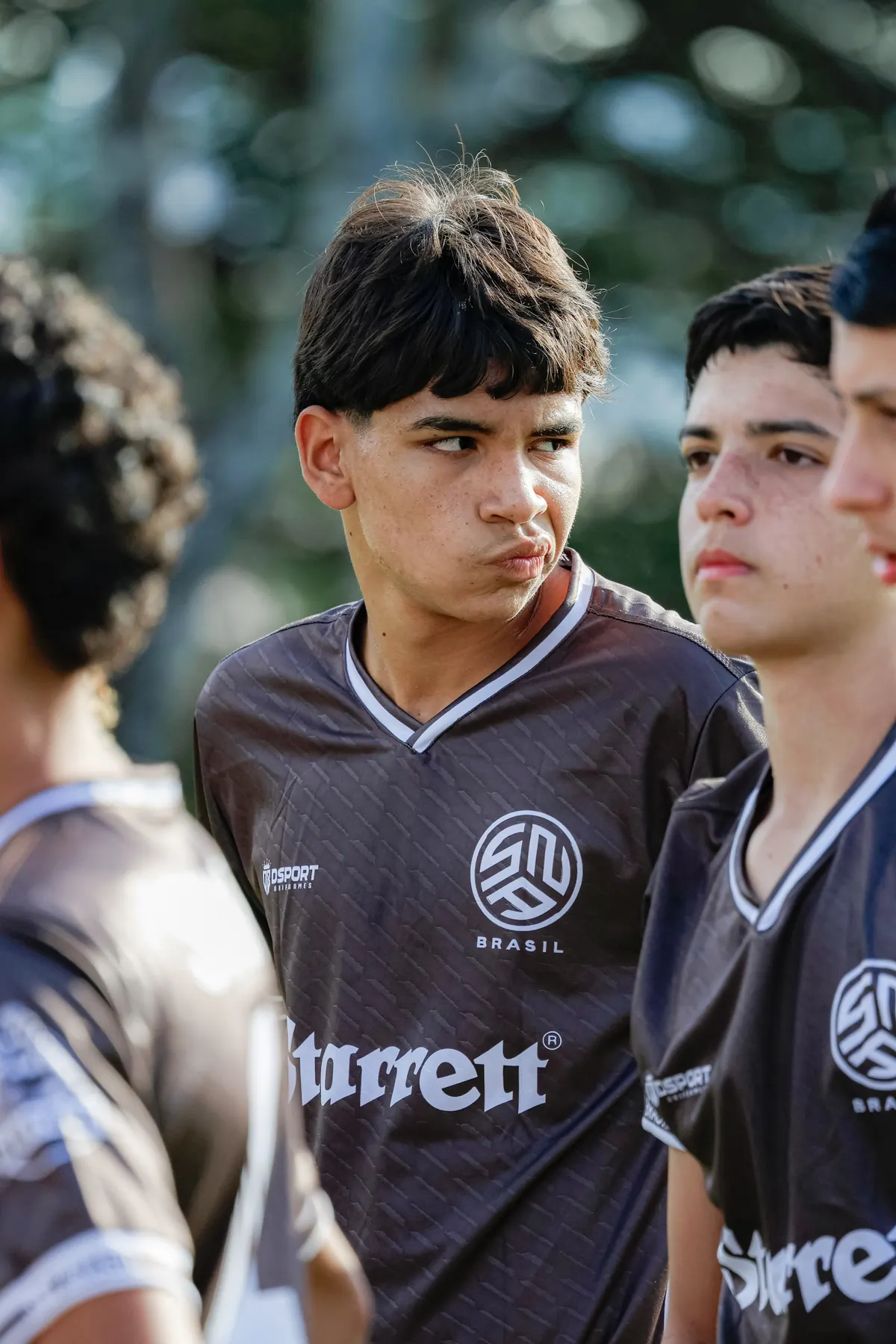 Jovens atletas da SNA Brasil com o uniforme marrom