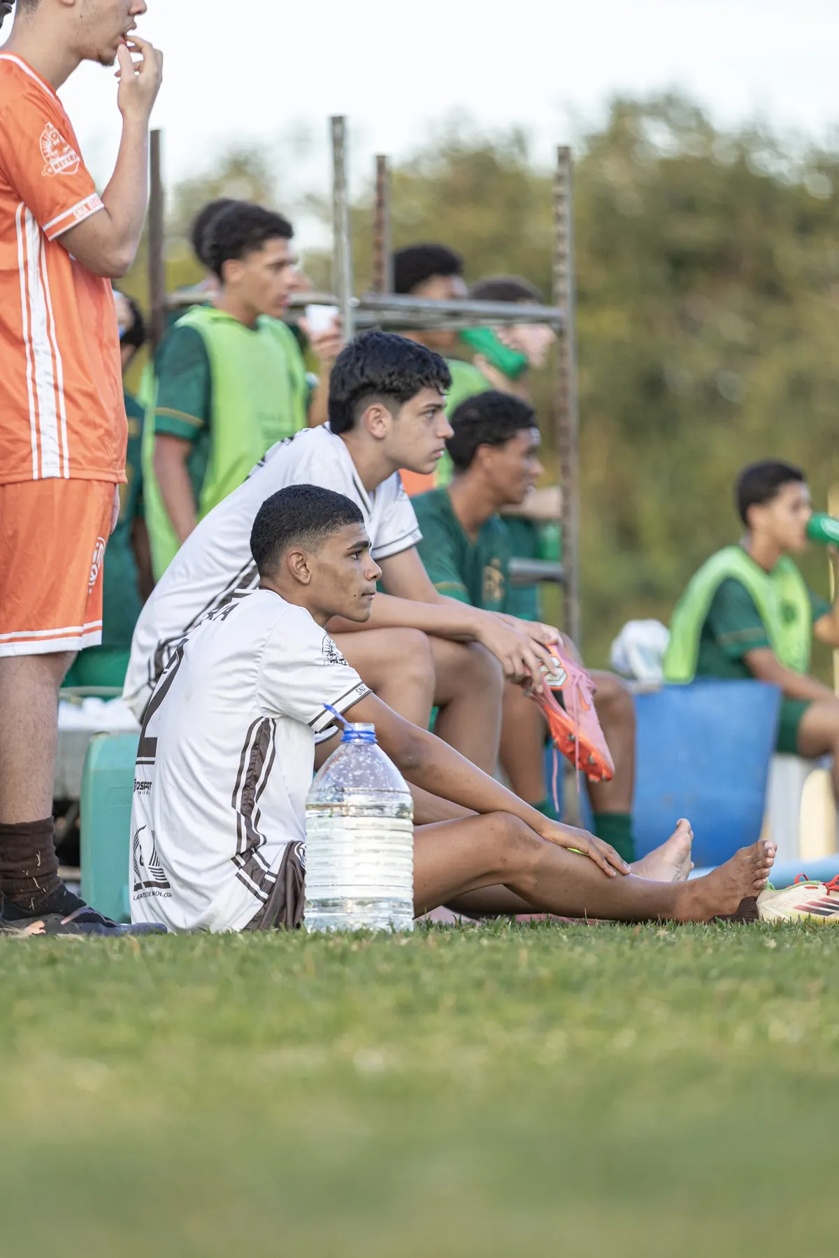 Atletas no banco de reservas acompanham o jogo
