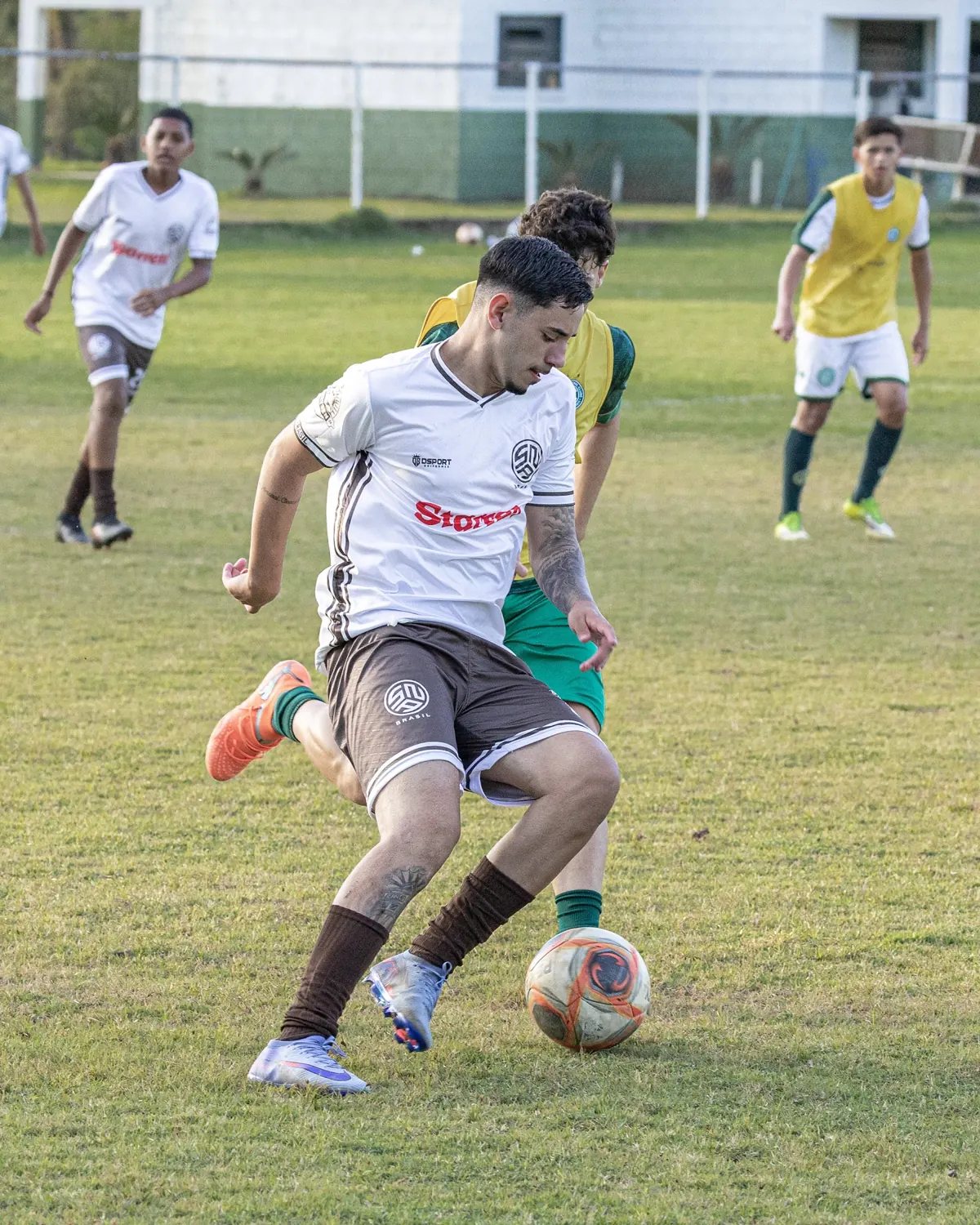 Atleta da SNA Brasil, de uniforme branco, conduz a bola